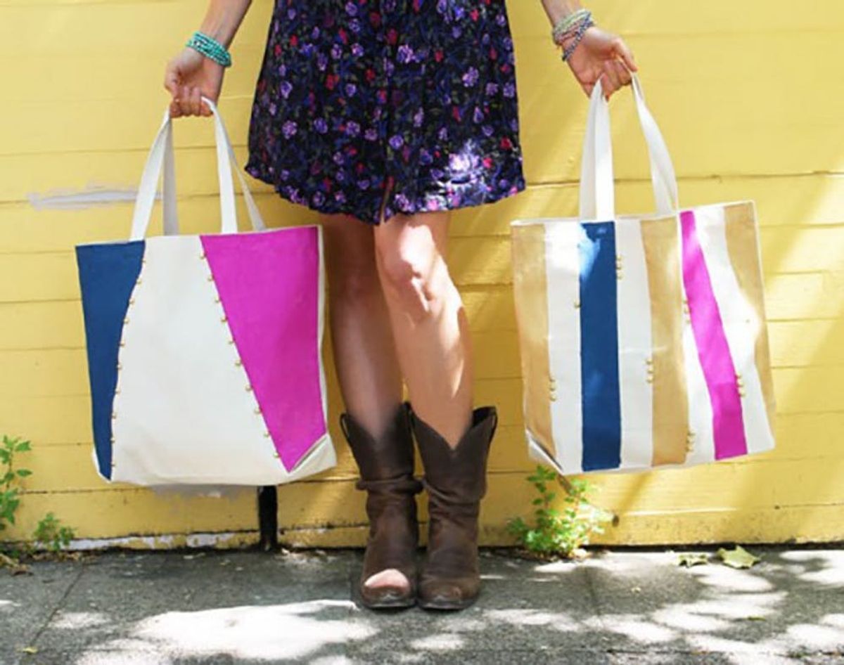 Flower skirt and cowboy boots feature Brit-Approved canvas tote bags against a pale light yellow wall.
