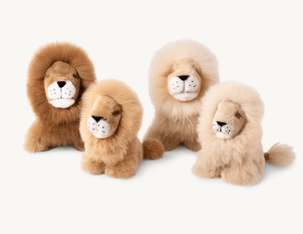 Four fluffy lion plush toys with varying shades of brown fur.