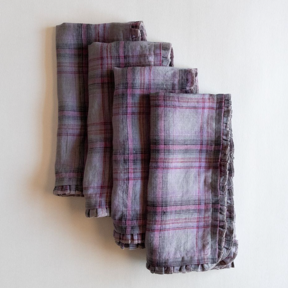 Four folded plaid napkins with red and black stripes on a light background.