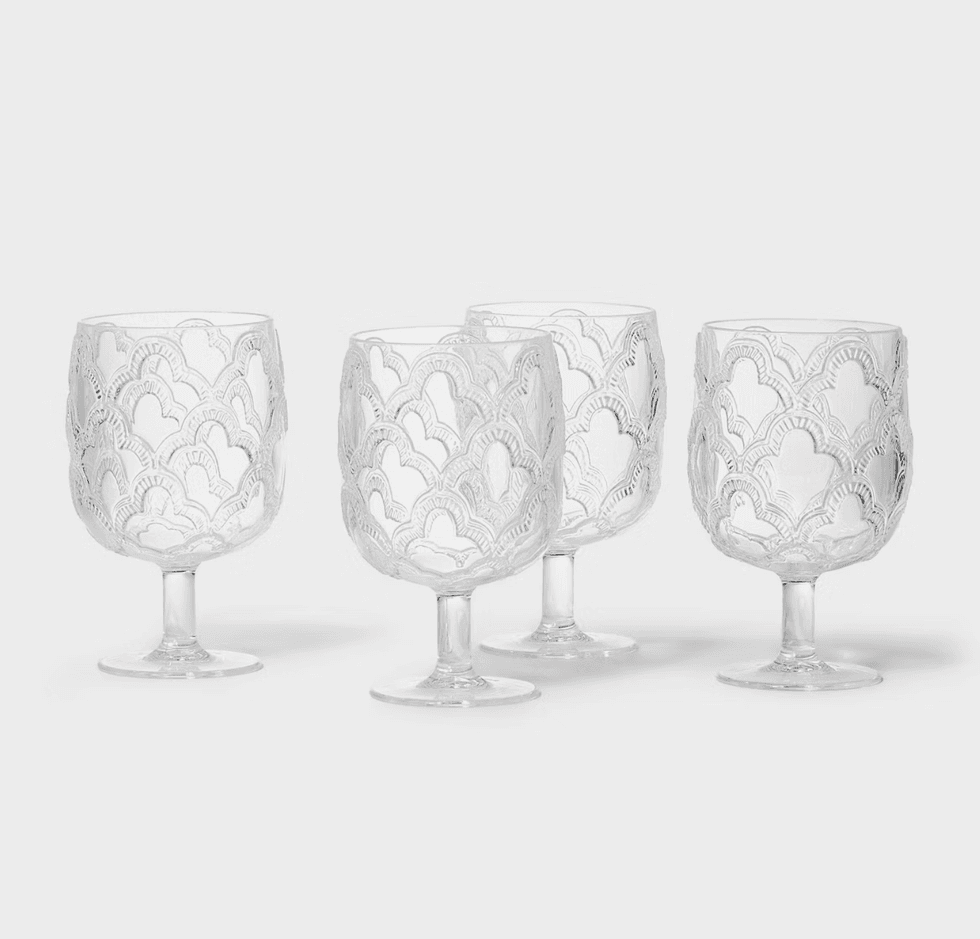 Four ornate wine glasses with intricate wave patterns on a white background.