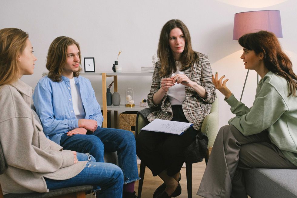 Four people engaged in a discussion in a cozy room with modern decor.