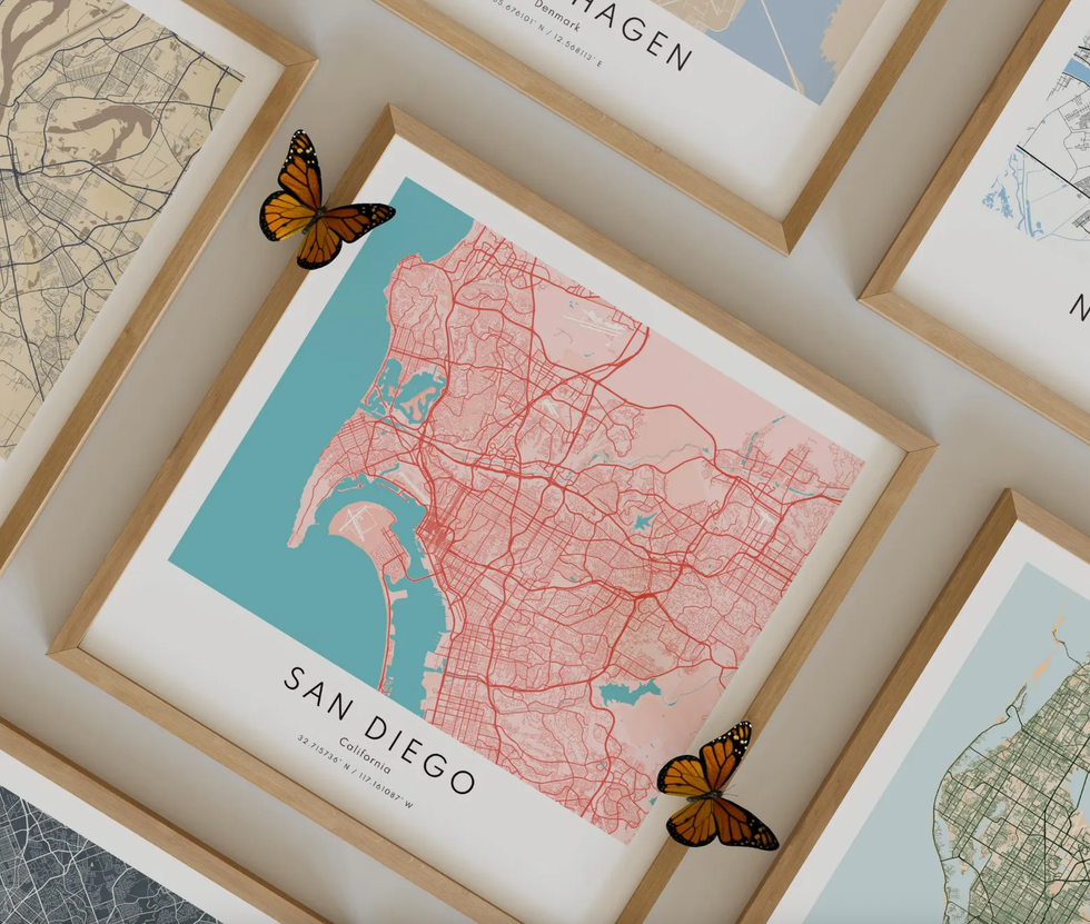 Framed city map prints with two butterflies, featuring San Diego prominently.