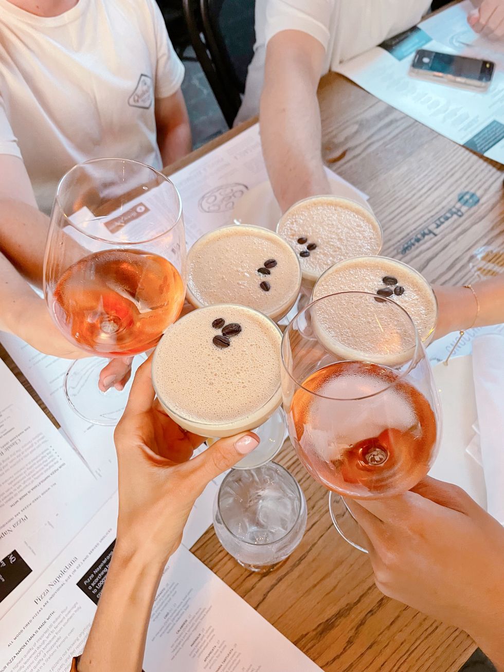 friends cheersing with aperol spritz and espresso martinis