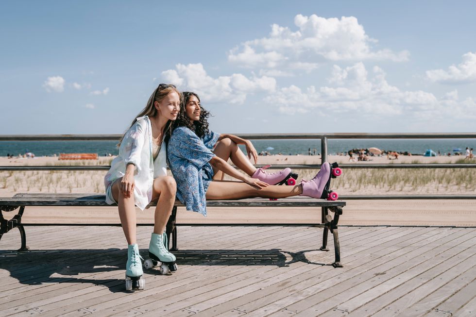 friends in rollerblades on beach boardwalk