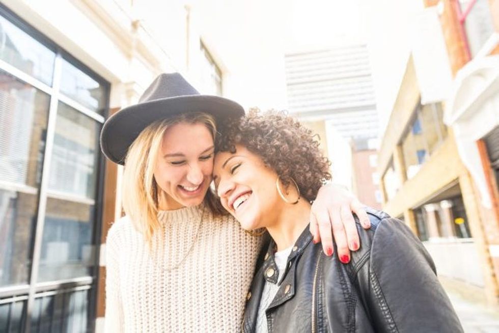 Friends in street hugging and smiling