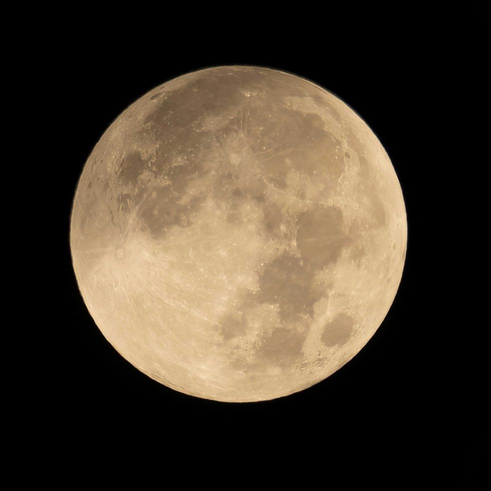 Full moon glowing brightly against a black night sky.