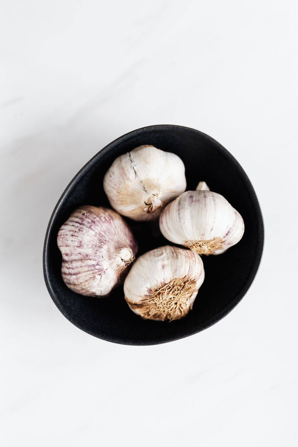 garlic heads in black bowl