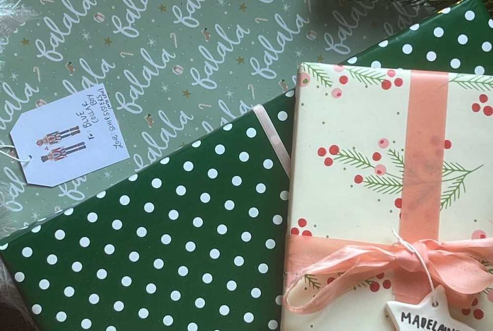 Gift boxes with festive wrapping: "falala" script, polka dots, and berries with a pink ribbon.