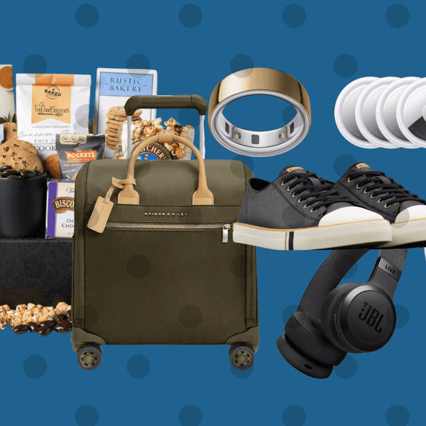 Gift set with snacks, luggage, sneakers, smartwatch, headphones on a blue polka dot background.