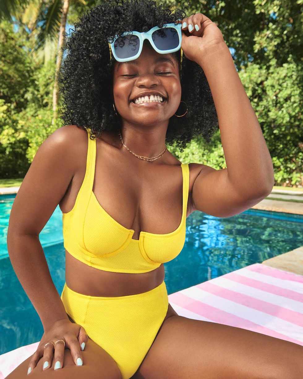 girl in a yellow bikini and blue sunglasses by the pool