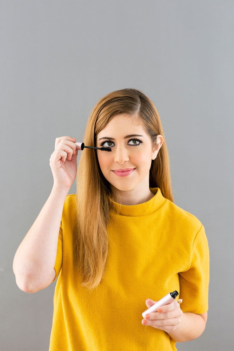 Girl wearing yellow shirt showing off spider lashes.