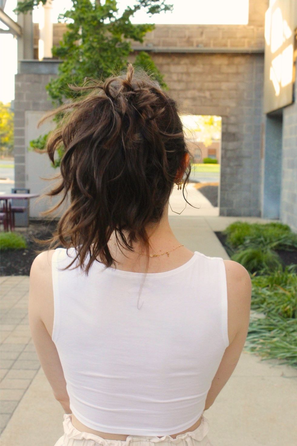 girl with a ponytail standing with her back to the camera