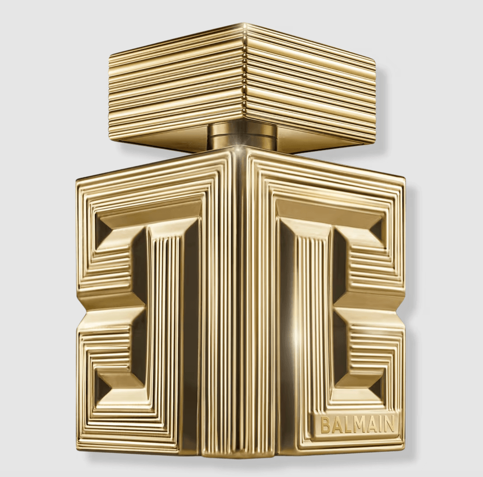 Gold geometric perfume bottle with embossed patterns and "Balmain" text.