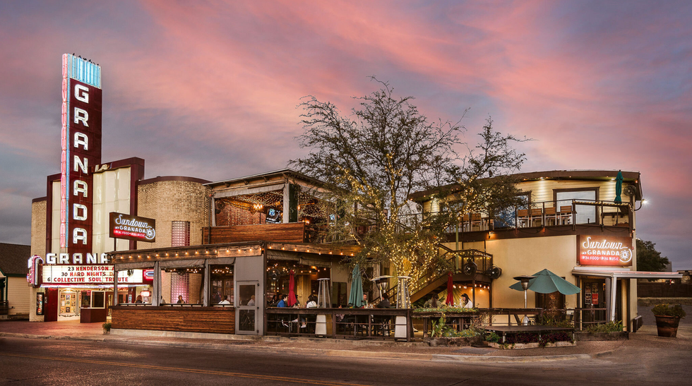 Granada Theater with lit marquee and adjacent rooftop patio at sunset.