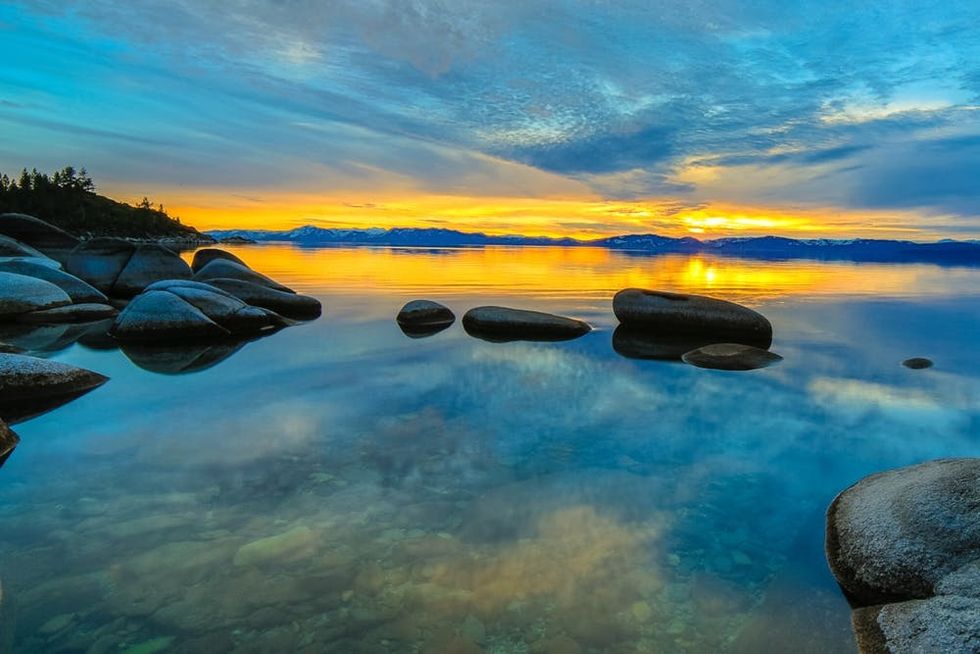 Granite boulders reflect in the surface of Lake Tahoe at sunset