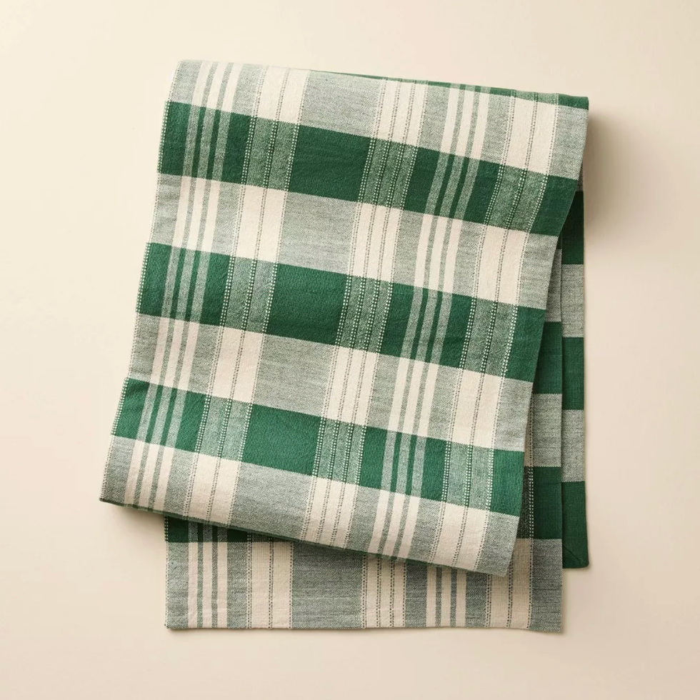 Green and white plaid cloth folded neatly on a light background.