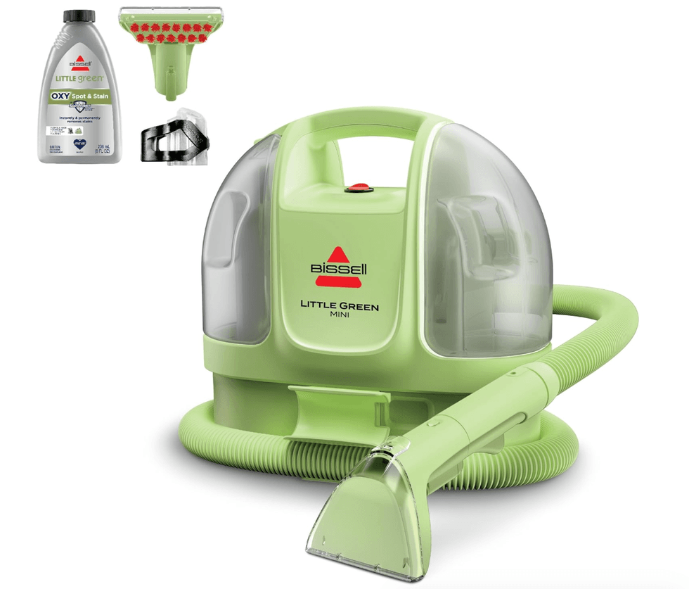 Green Bissell Little Green Mini vacuum with attachments and stain remover bottle.
