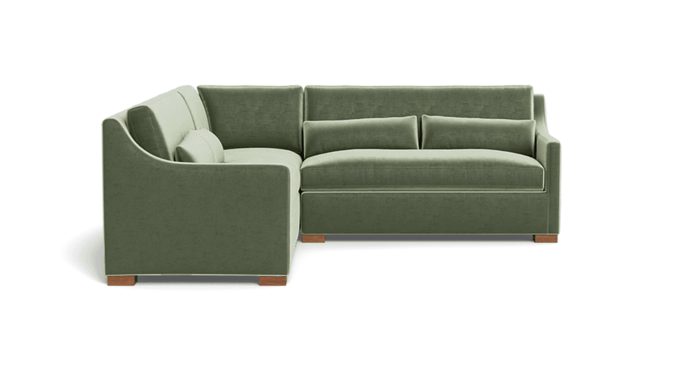 Green L-shaped sectional sofa with wooden legs, featuring plush cushions and armrests.