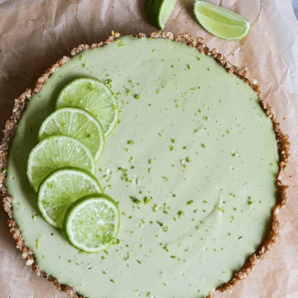 Green tart with lime slices on parchment paper.