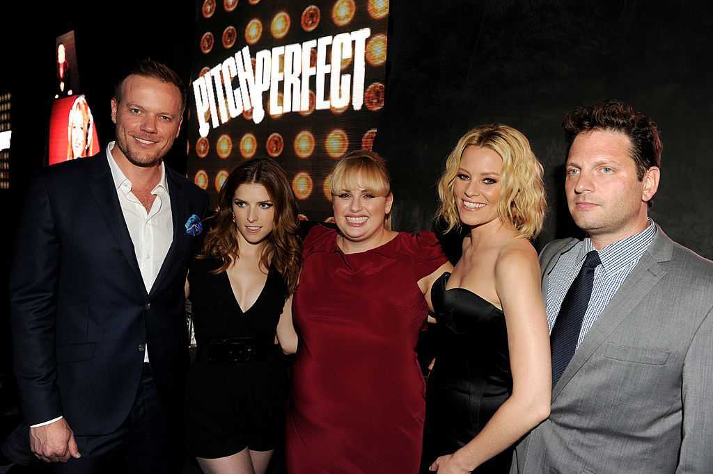 Group of five people at "Pitch Perfect" event, smiling in front of the movie logo.