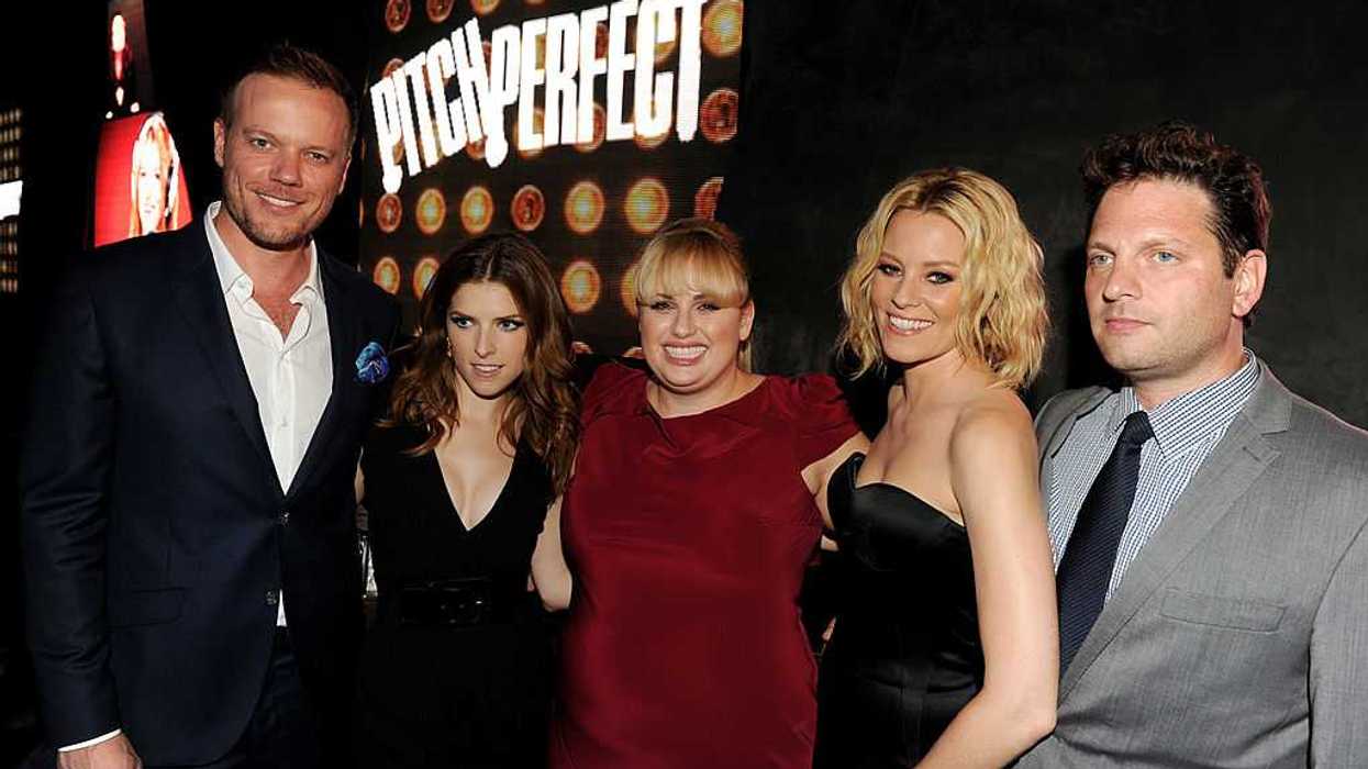 Group of five people at "Pitch Perfect" event, smiling in front of the movie logo.