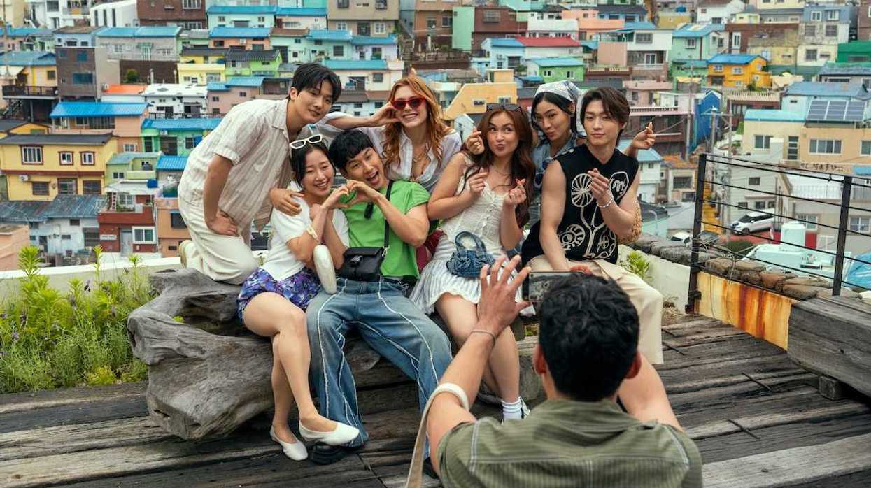 Group of friends posing for a photo with colorful houses in the background.
