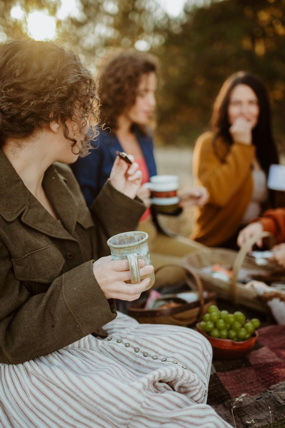 Group of women enjoying an outdoor picnic in a sunny setting.