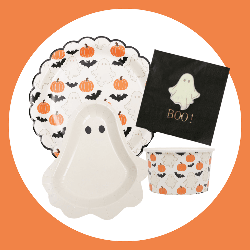 Halloween tableware set with ghosts, pumpkins, and bats on orange background.