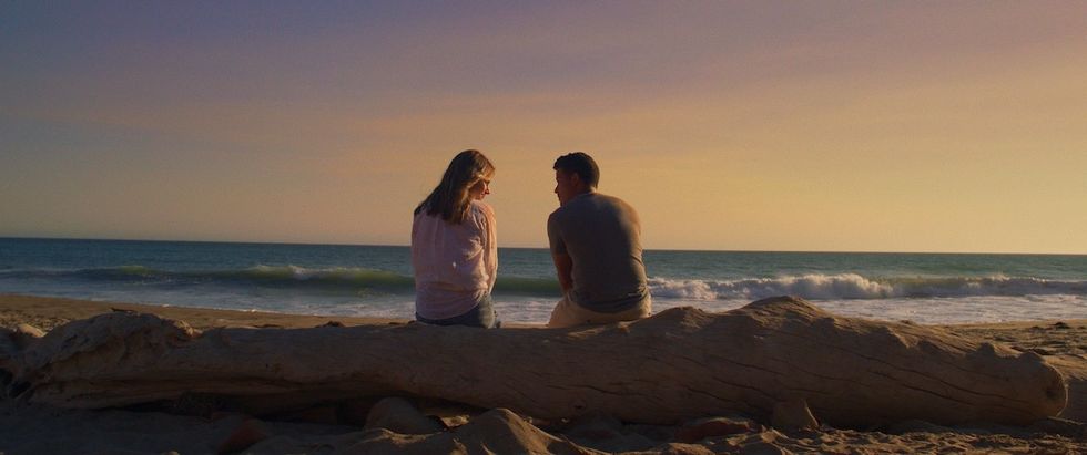 halston sage and christian navarro sitting on the beach