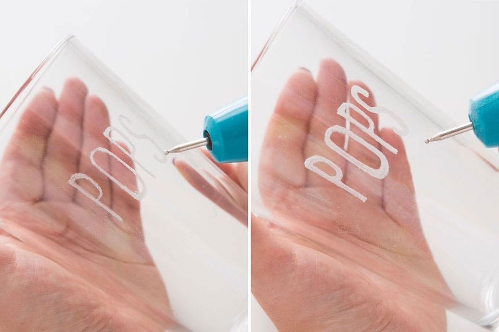 Hand engraving "POPS" on glass with a blue engraver tool.