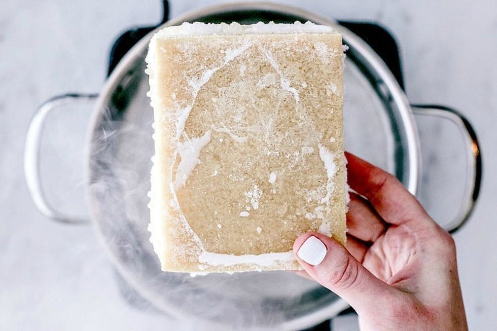 hand holding a block of frozen tofu