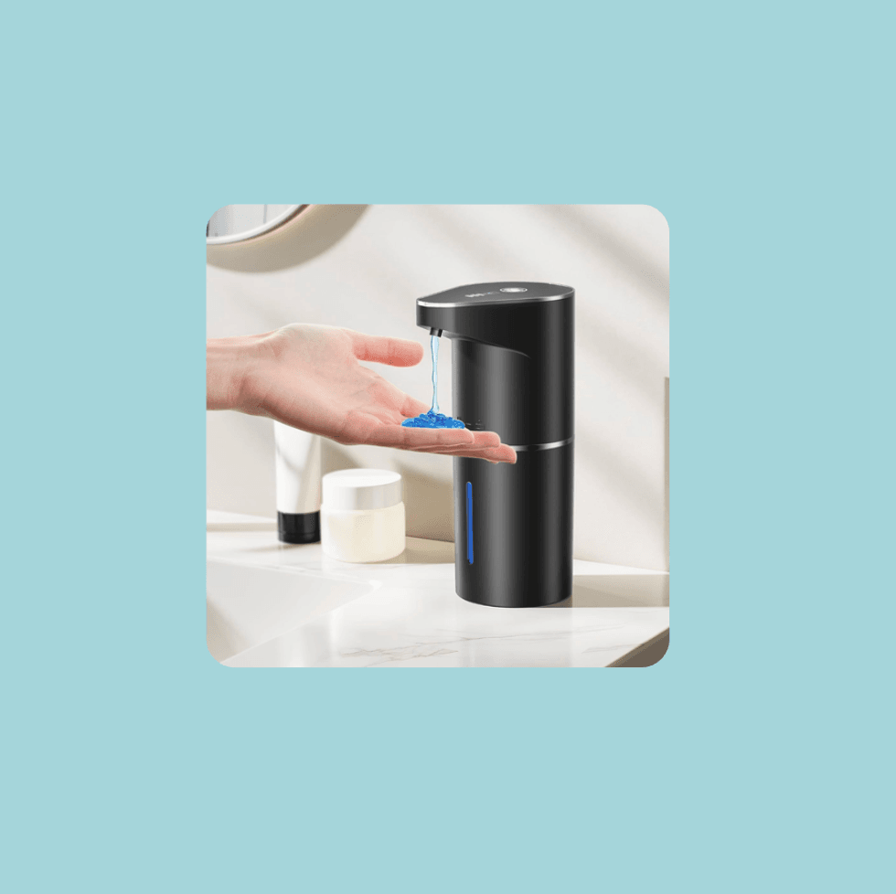 Hand receiving blue liquid from a black automatic dispenser on a bathroom counter.