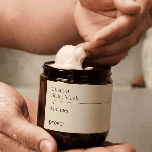Hand scooping cream from a jar labeled "Custom Scalp Mask for Michael."