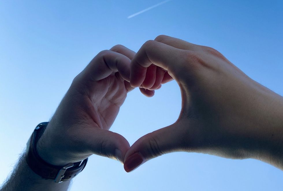 hands making a heart in the sky