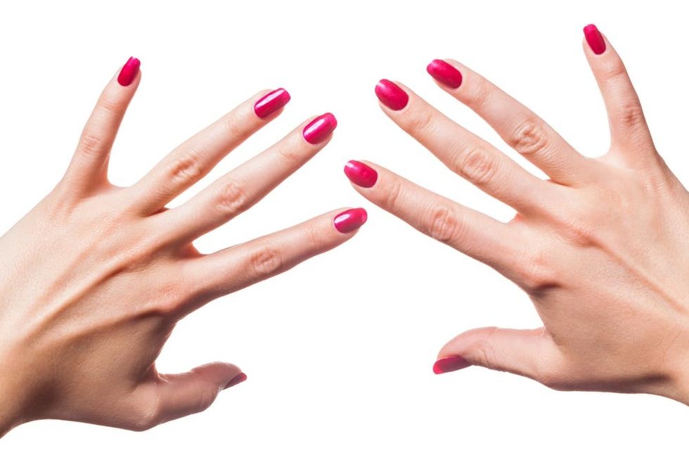 Hands with red fingernails against a white background.