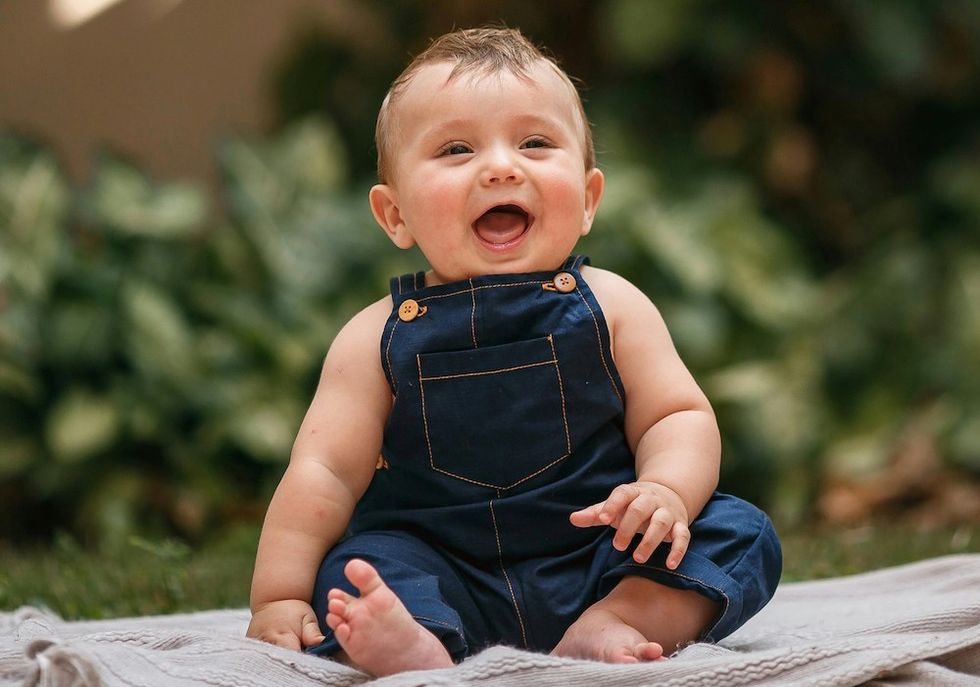 happy baby in denim overalls