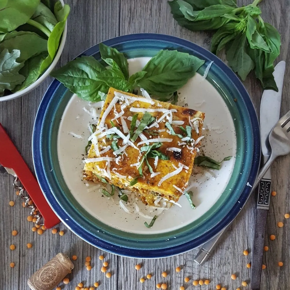 Homemade Moussaka on a small plate pictured with cutlery