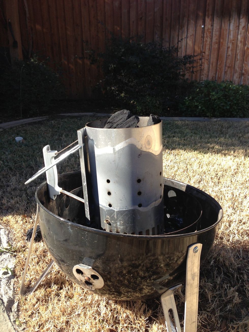 I have a vertical smoker, so I like to get the natural lump charcoal going in a chimney first. Whatever you have, time to get it lit.