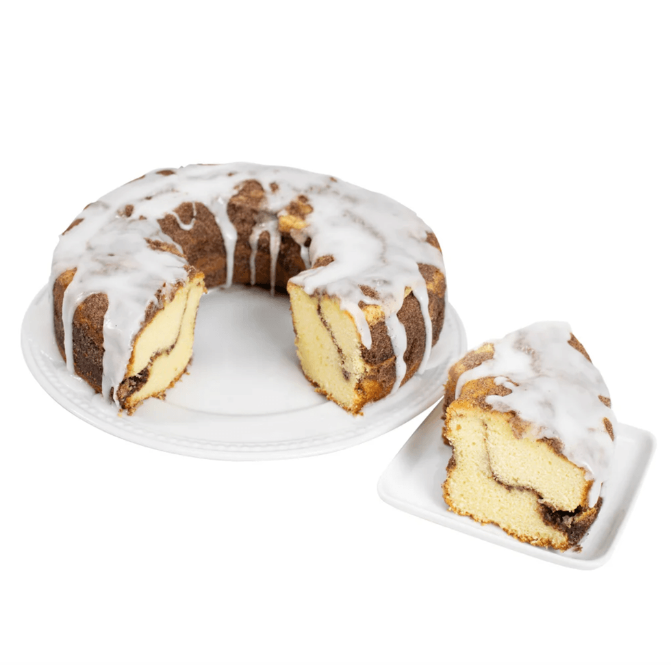 Iced Bundt cake with a visible swirl, plus a separate slice on a small plate.