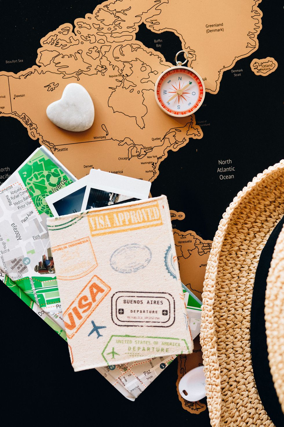 image of travel gear such as maps, compass, passport, travel hat