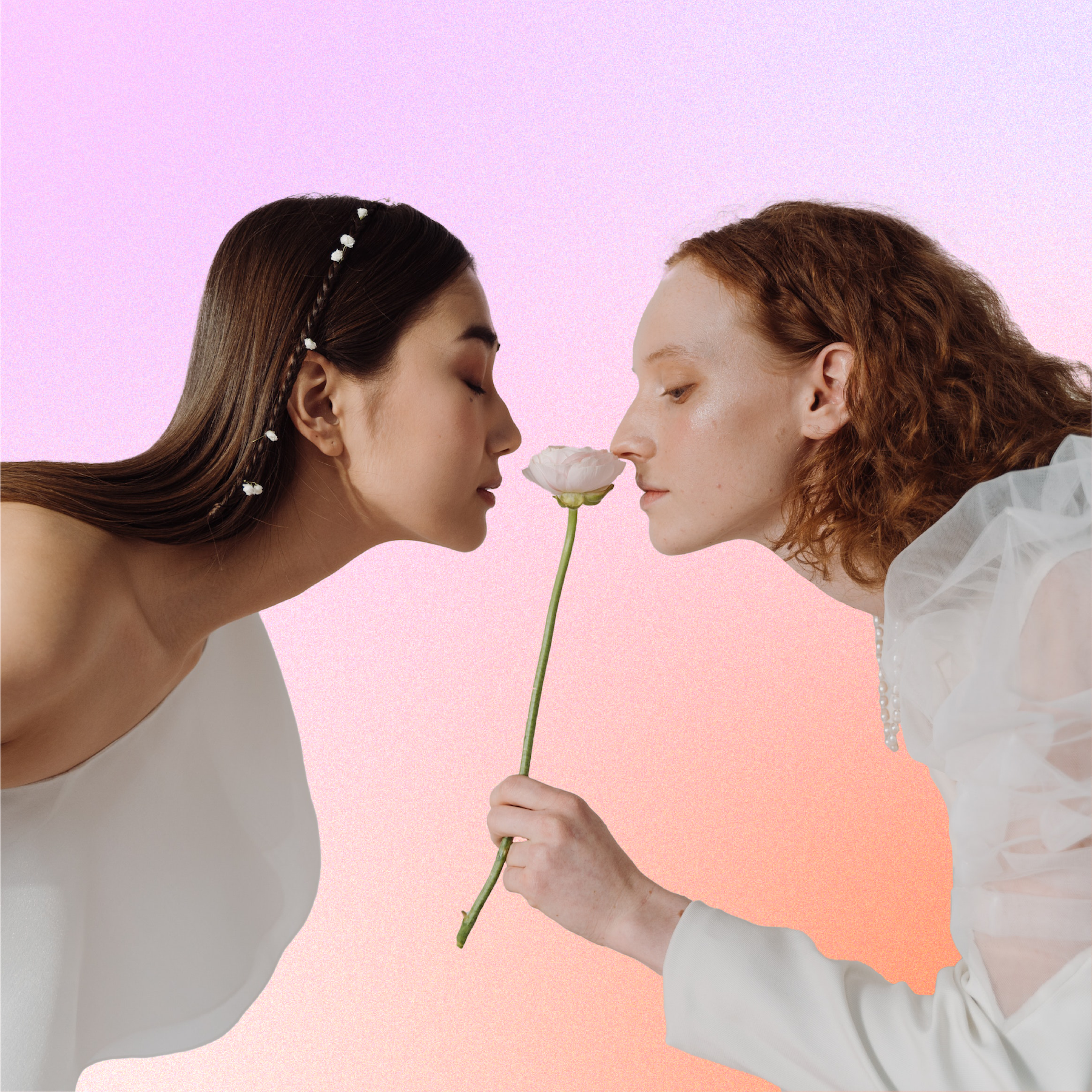 two women smelling a flower