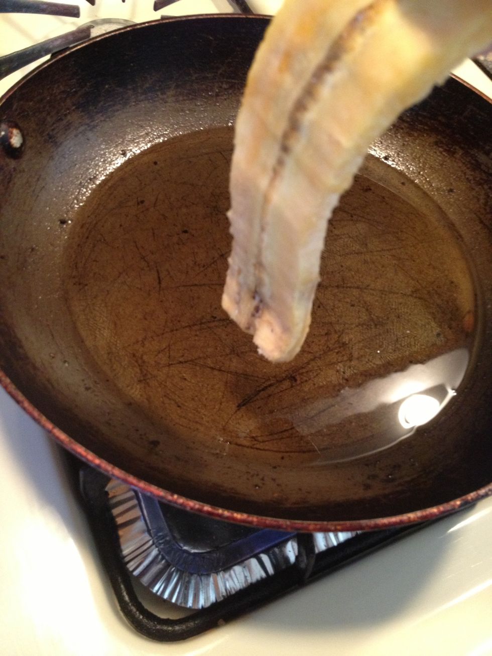 In a pan over medium high heat. Add 1cup of oil. When the oil is hot start adding the plantains. Fry up each side until browned.