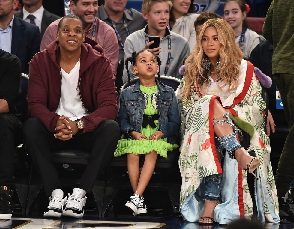 Jay-Z, Beyonc\u00e9, and daughter Blue Ivy sitting courtside at a basketball game