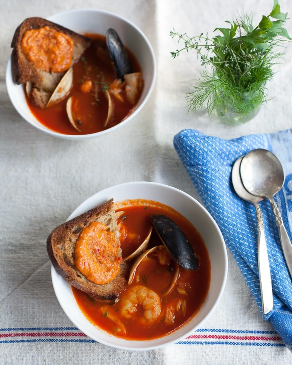 Julia Child's Bouillabaisse pictured with spoons and small plant