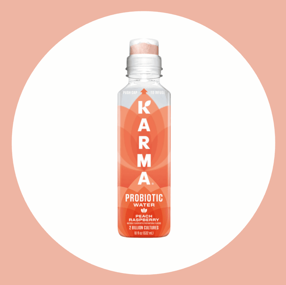 Karma probiotic water bottle, peach raspberry flavor, against a two-tone circle background.