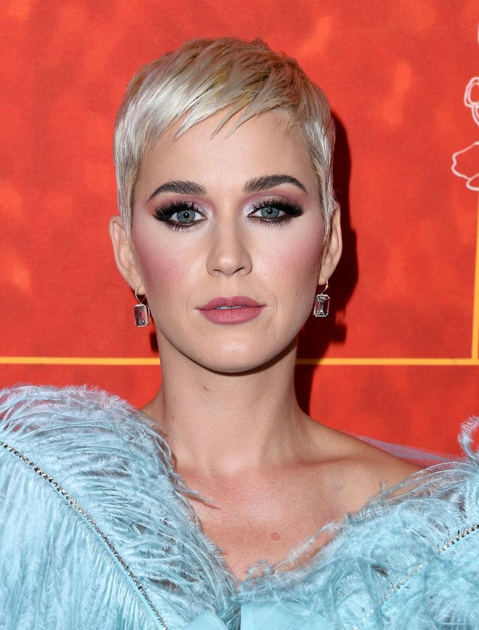 Katy Perry showcasing a platinum blonde pixie haircut.