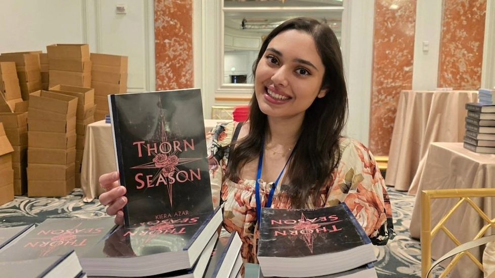 kiera azar holding her 'thorn season' romantasy book