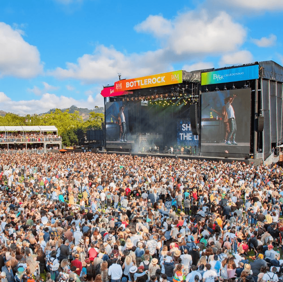 Large outdoor concert crowd at BottleRock with stage and screens in view.