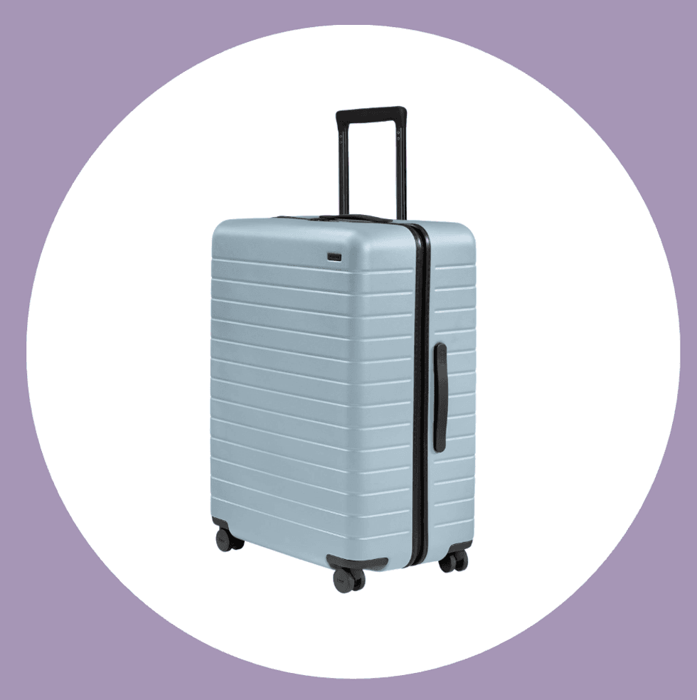 Light blue hardshell suitcase with black handle and wheels on purple background.