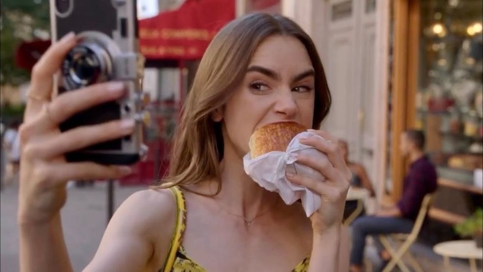lily collins eating a croissant in emily in paris